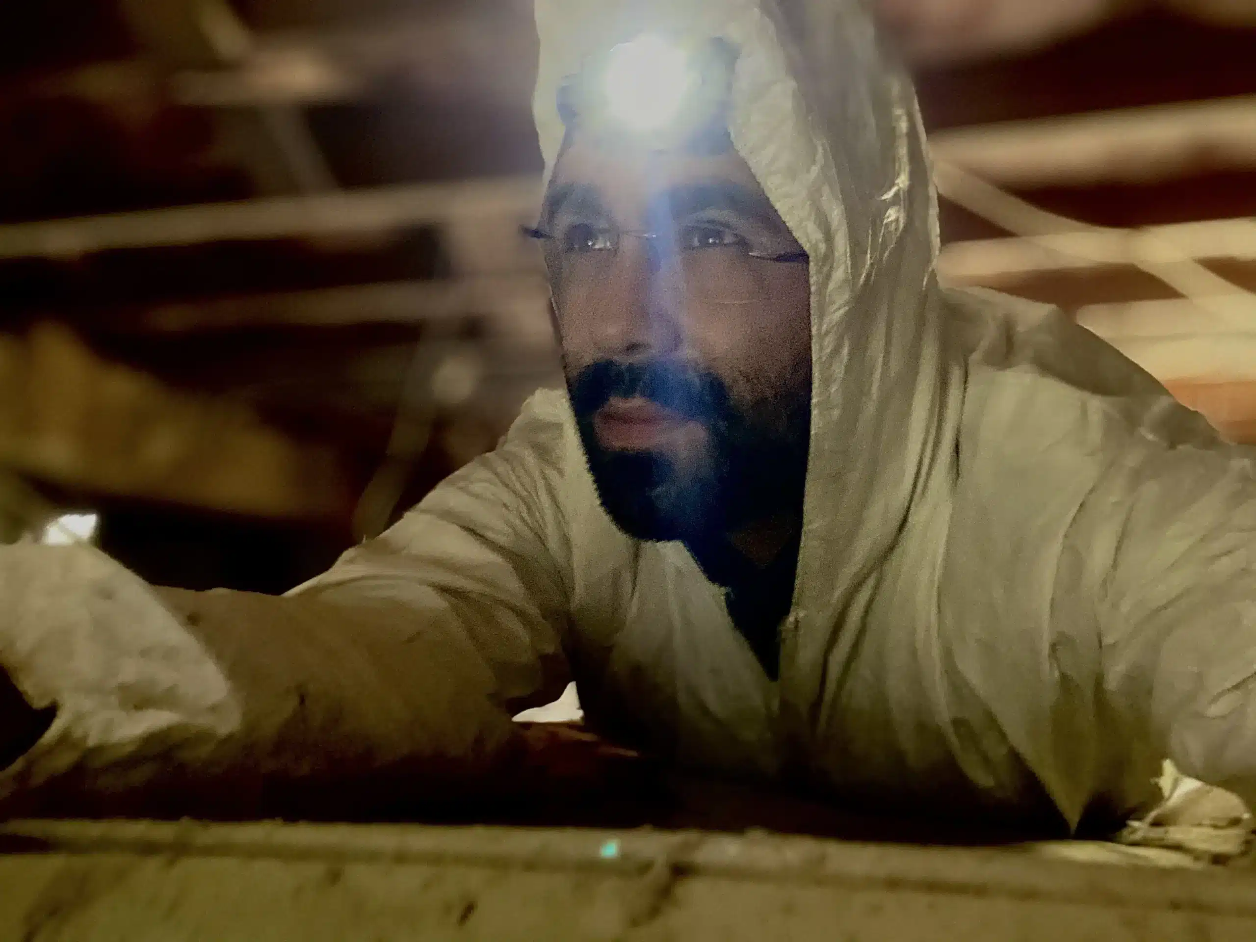 Home inspector in a tyvek suit with headlamp demonstates the importance of a thorough inspection.